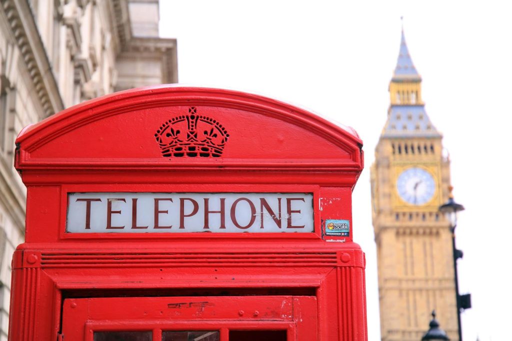 Classic red telephone booth with Big Ben in the background, symbolizing London.