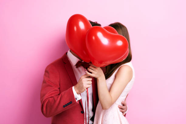 Couple kissing behind balloons